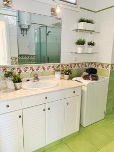 ein Badezimmer mit einem Waschbecken, einem Spiegel und Blumen in der Unterkunft relax in Candelaria
