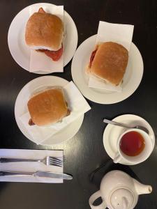 four white plates with sandwiches and a cup of tea at No12 Hotel in North Berwick
