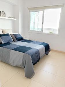 a large bed in a white room with a window at relax in Candelaria
