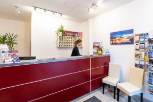 a woman standing at the cashier counter of a pharmacy at Aparthotel Neumarkt in Dresden