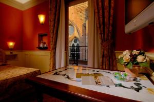 a hotel room with a desk with a vase of flowers at Art Hotel Commercianti in Bologna