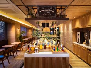 a restaurant with a bar with tables and chairs at Super Hotel Okayama Station Higashiguchi in Okayama