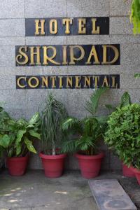 a hotel sign with potted plants in front of it at Hotel Shripad Continental in Amravati