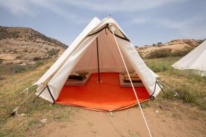 ein weißes und orangefarbenes Zelt auf einem Feld in der Unterkunft Rummana Campsite in Dana
