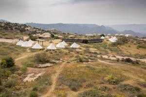 a group of tents in a field with mountains in the background at Rummana Campsite in Dana