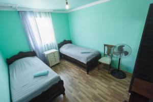 a blue room with two beds and a fan at Guesthouse Gorgasali 57 in Batumi