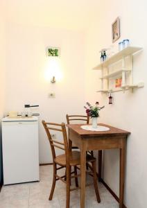 een keuken met een tafel en 2 stoelen en een koelkast bij Apartment or room at Irena's in Piran
