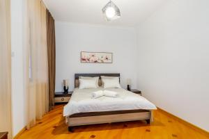 1 dormitorio con 1 cama con sábanas blancas y suelo de madera en Guesthouse Alvani, en Nizhniy Alvani 58 fotos más