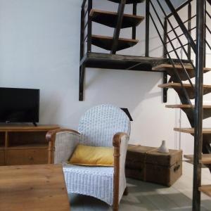 a living room with a chair and a staircase at Au galet bleu in Dieppe