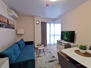 a living room with a blue couch and a tv at Cozy Palanga in Palanga