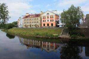 a large building sitting next to a body of water at Golden Embankment in Pskov
