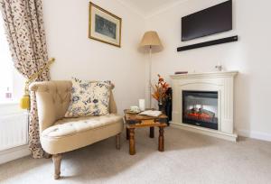 a living room with a chair and a fireplace at Berwick in Wimborne Minster