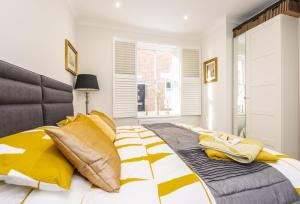 a bedroom with a large bed with yellow pillows at Berwick in Wimborne Minster