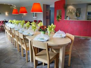 een lange tafel in een restaurant met stoelen en tafelblad bij Spacious Villa in Ovifat with Sauna in Ovifat