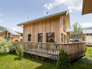 una pequeña casa de madera con terraza de madera en Modern Wooden Chalet in Sankt Georgen ob Murau with Jacuzzi, en Sankt Lorenzen ob Murau