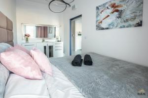 a bedroom with a bed with a pair of shoes on it at K&K Apartament blisko Centrum Near City Center in Warsaw