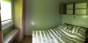 a bed in a small room with a window at Lipót Termál Camping in Lipót +42 photos