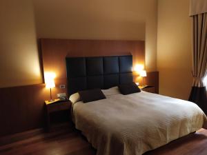 a bedroom with a large white bed with two lamps at Hotel Porta Felice & Spa in Palermo