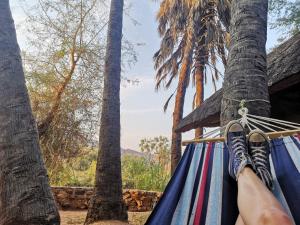 a person laying in a hammock with their feet up at Omarunga Epupa-Falls Campsite in Epupa