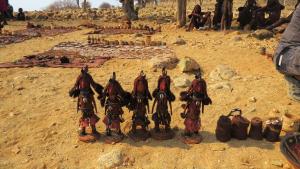 a group of figurines sitting on the ground in the dirt at Omarunga Epupa-Falls Campsite in Epupa
