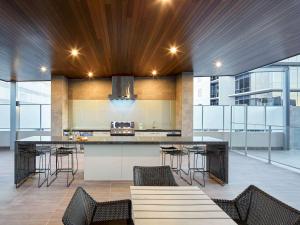 una cocina abierta con una gran isla con taburetes de bar en The Sebel West Perth en Perth