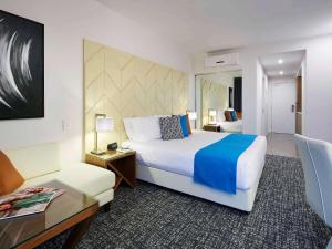 a hotel room with a large bed and a table at The Sebel West Perth in Perth