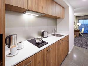 a kitchen with two coffee cups and a sink at The Sebel West Perth in Perth
