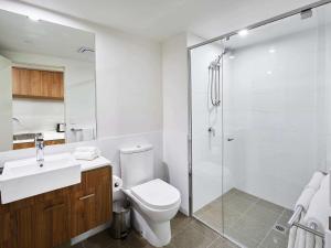 a white toilet sitting next to a shower in a bathroom at The Sebel West Perth in Perth