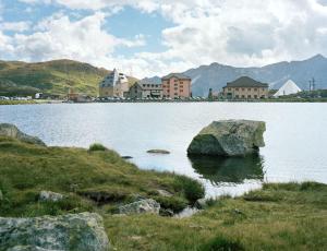 a large rock in the middle of a large lake at Ospizio San Gottardo in Airolo