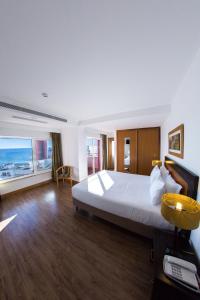 a hotel room with a large bed and a large window at Hotel Quarteirasol in Quarteira +18 photos