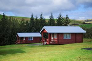 a couple of red cabins in a field at Hunkubakkar Guesthouse in Kirkjubæjarklaustur