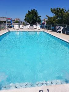 a large swimming pool with blue water in a resort at Oceanic Motel in Ocean City