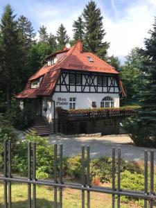 ein Haus mit rotem Dach und einem Zaun in der Unterkunft Mon Plaisir in Karpacz