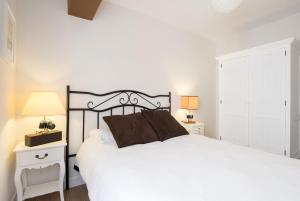 マラガにあるMalagaSuite Historic City Centreのベッドルーム1室(白い大型ベッド1台、ナイトスタンド2台付)