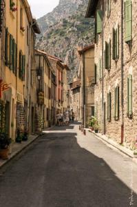 an empty street with buildings and a mountain in the background at Maison les Ramparts in Villefranche-de-Conflent