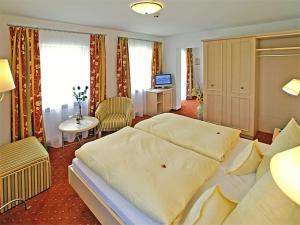 a hotel room with a large bed and a table at Hotel Hagerhof in Thiersee