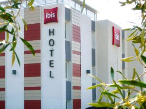 un bâtiment avec le panneau ibis sur celui-ci dans l'établissement ibis Salon de Provence, à Salon-de-Provence