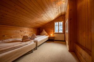 una camera con due letti in una cabina di legno di Chalet Weid - Aare Jungfrau AG a Grindelwald