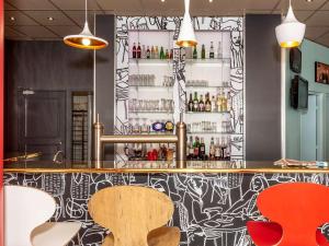 a bar with a black and white patterned wall at ibis Saint-Die in Saint Die