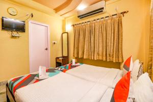 a hotel room with two beds and a tv at FabExpress Harry inn in Kolkata