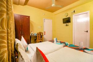 a hotel room with two beds and a television at FabExpress Harry inn in Kolkata