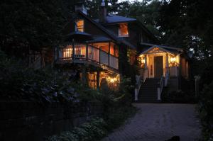 a house with lights on the porch at night at Plantation House Bed & Breakfast in Port Hope