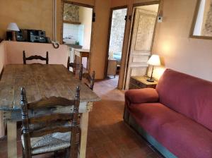 Una sala de estar con una mesa de madera y un sofá. en Ca la iaia Veva, en Sant Joan les Fonts