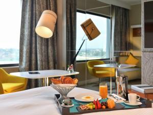 a hotel room with a tray of food on a bed at Pullman Abidjan in Abidjan