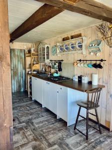 eine Küche mit weißen Schränken und einem Holztisch in der Unterkunft Domek PoZiomek in Życiny
