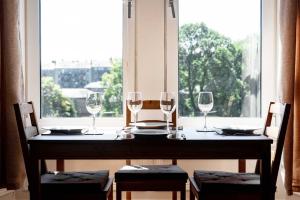 a table with wine glasses on it with a window at Bright, Spacious West-End Flat, Near University in Dundee