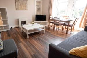 a living room with a table and a dining room at Bright, Spacious West-End Flat, Near University in Dundee