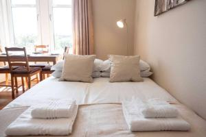 a bedroom with a large white bed with two pillows at Bright, Spacious West-End Flat, Near University in Dundee