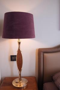 una lámpara sobre una mesa con una cortina púrpura en Ai tre cedri B&B, en Bolonia