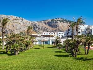 un complexe avec des palmiers et une montagne en arrière-plan dans l'établissement Saracen Sands Hotel & Congress Centre - Palermo, à Isola delle Femmine